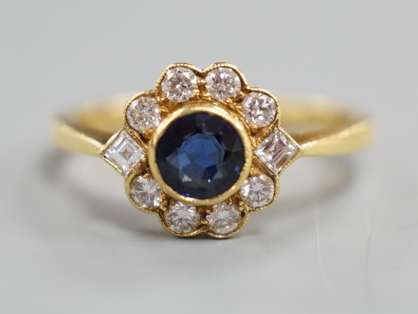 A modern 18ct gold, collet set sapphire and diamond set circular cluster ring, size O, gross weight 3.6 grams